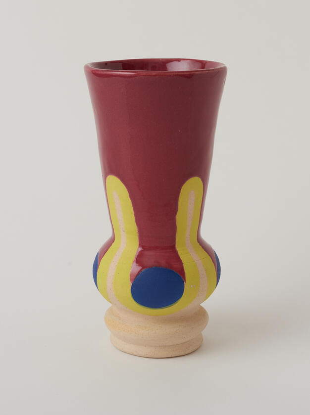 Maroon, chartreuse, and blue vase with rounded bottom.