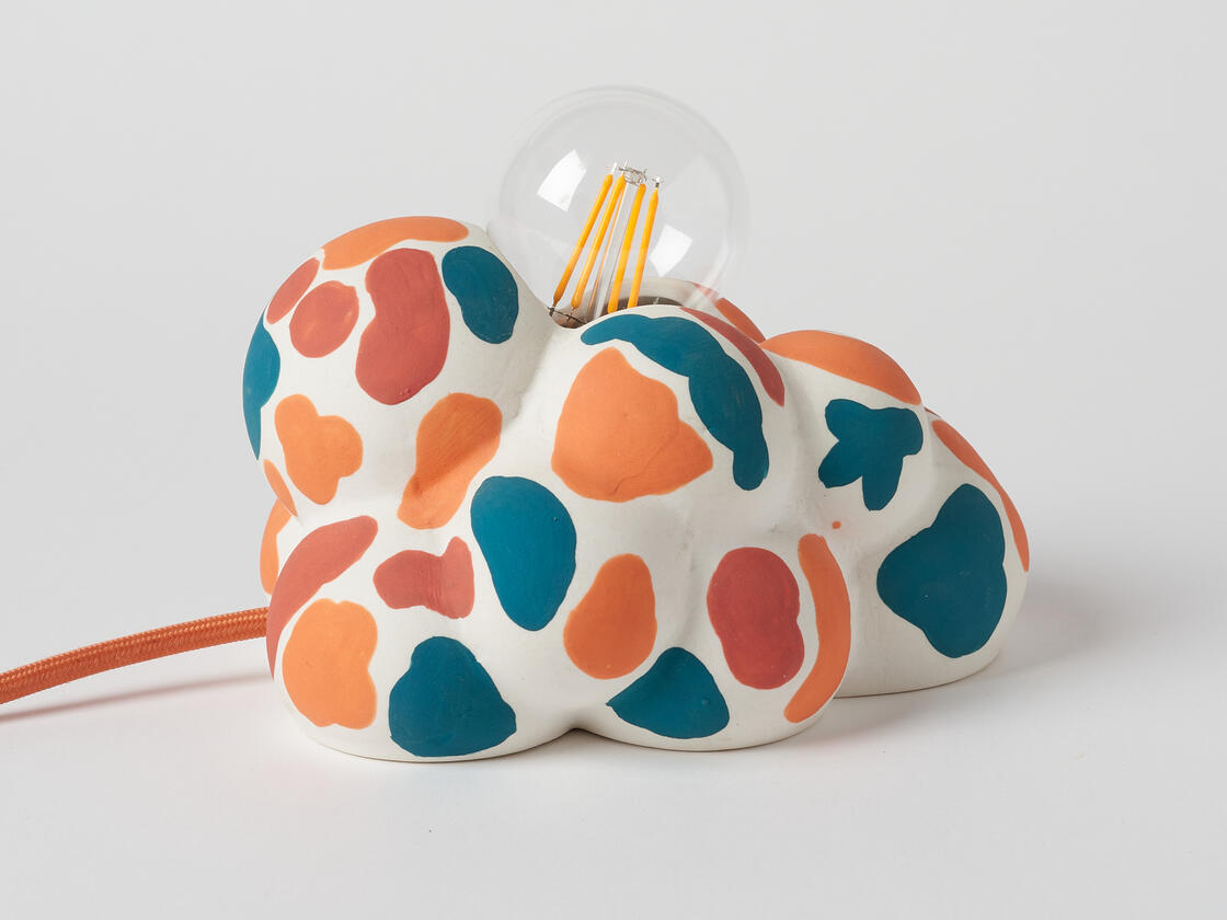 Amorphous cloud-like lamp form with multicolor spots.